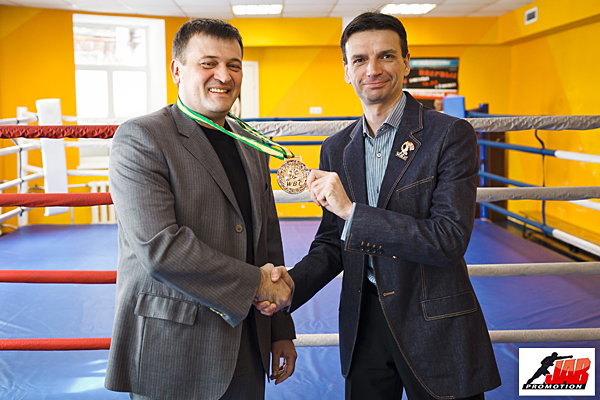 Михаил Денисов вручает медаль президенту Джеб промоушн Виталию Супиченко